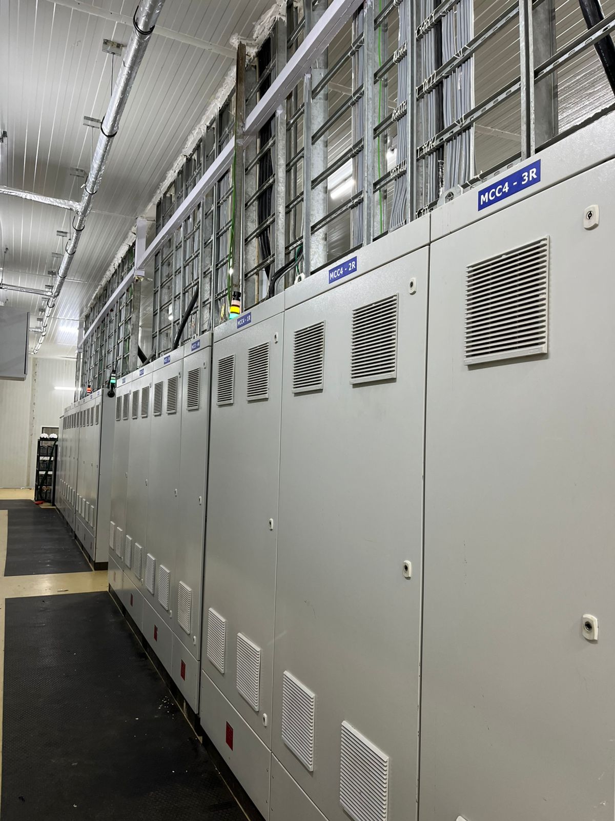 A row of white electrical cabinets, labeled "MCC," in a clean industrial room.